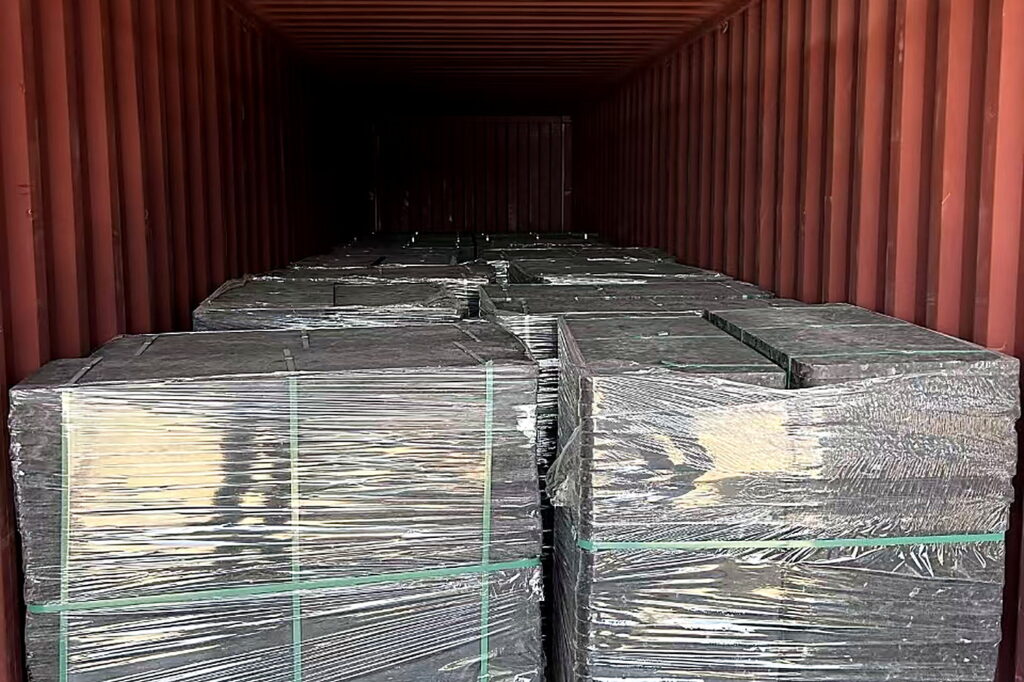 Molded wood pallets loaded with goods inside a shipping container