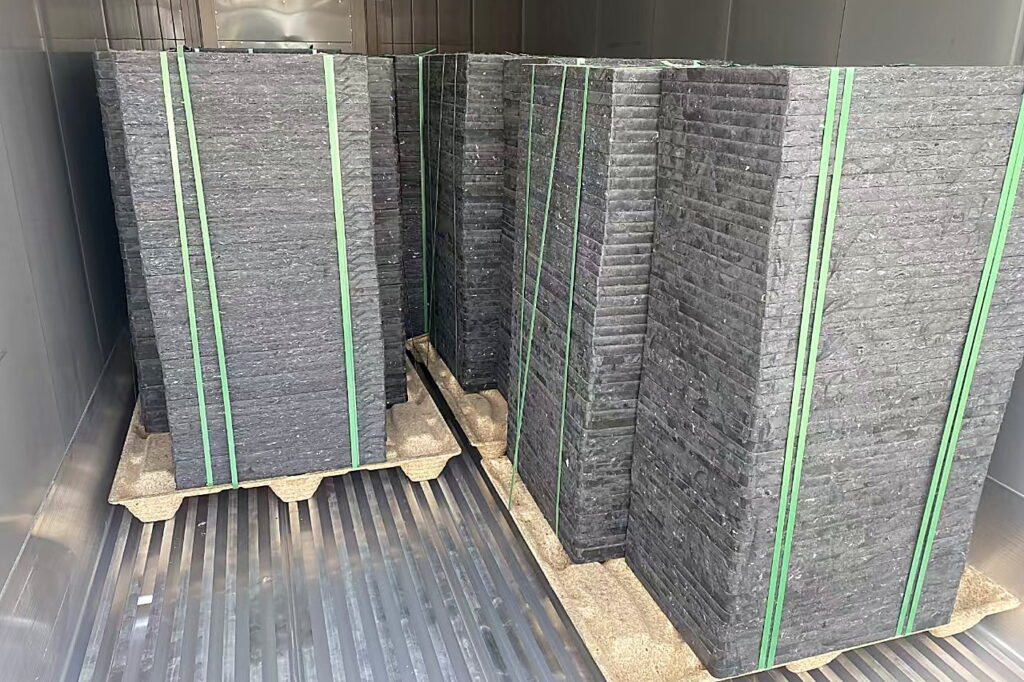 Presswood pallets strapped and loaded inside a container for export