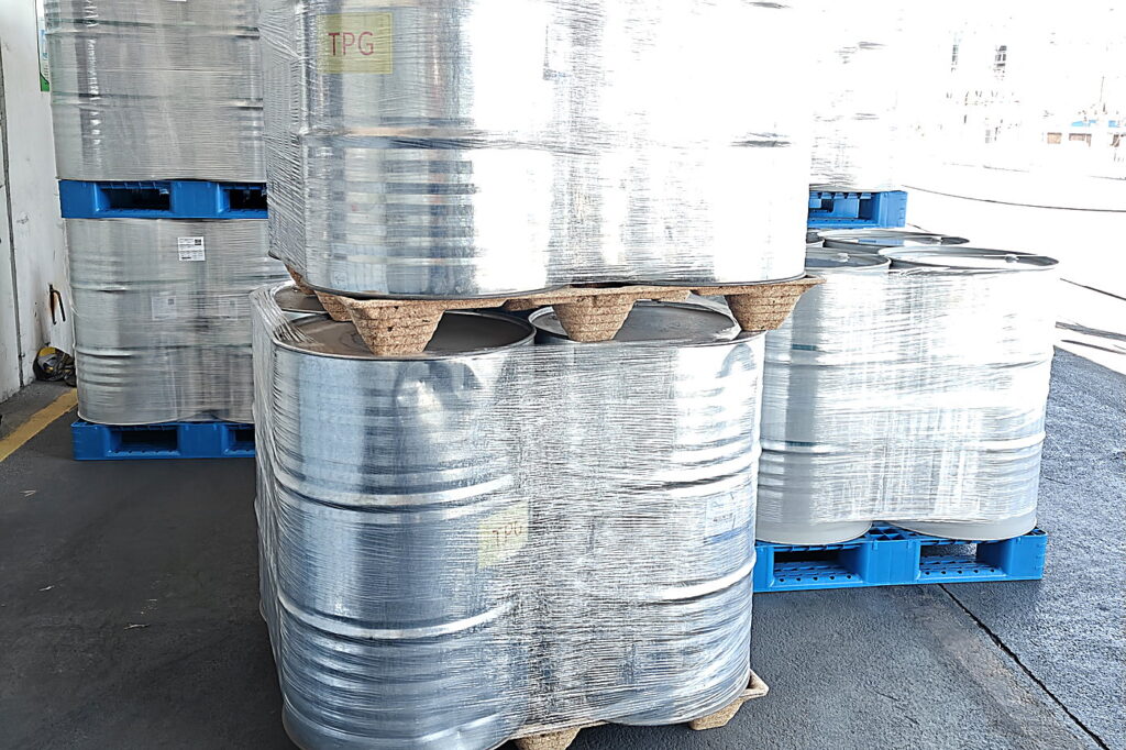 Presswood pallets with chemical drums stored in a plant warehouse